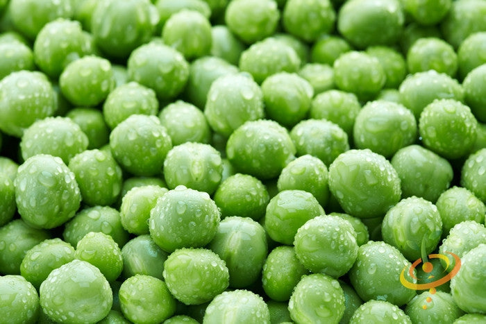 Close-up of fresh green peas with water droplets, representing Progress No. 9 seeds