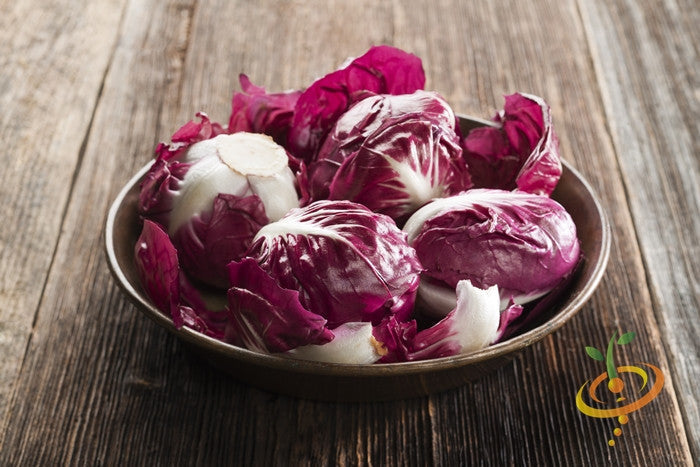 Radicchio Classic Red Italian chicory with white-veined red leaves in a bowl on wooden surface